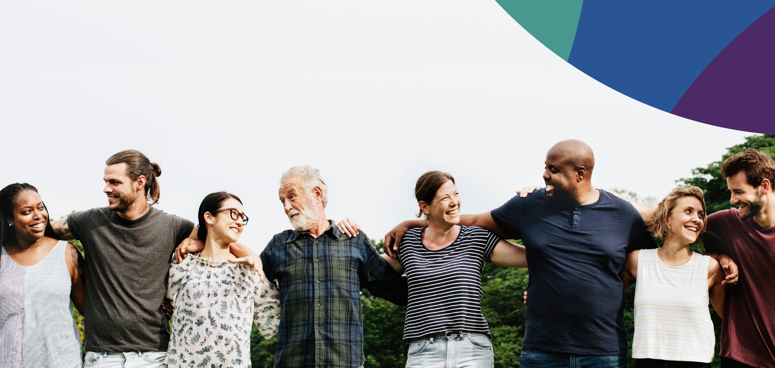 Diverse group of eight adults standing shoulder to shoulder with arms embracing each other