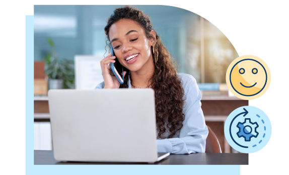 Woman smiling and talking on her smartphone while looking at her laptop