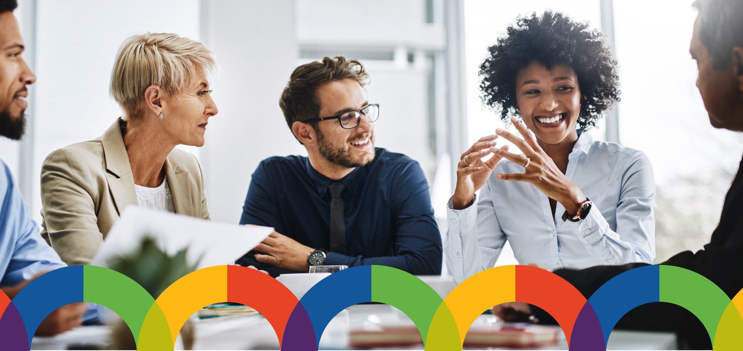 Diverse group of adults sitting and talking to each other at a table