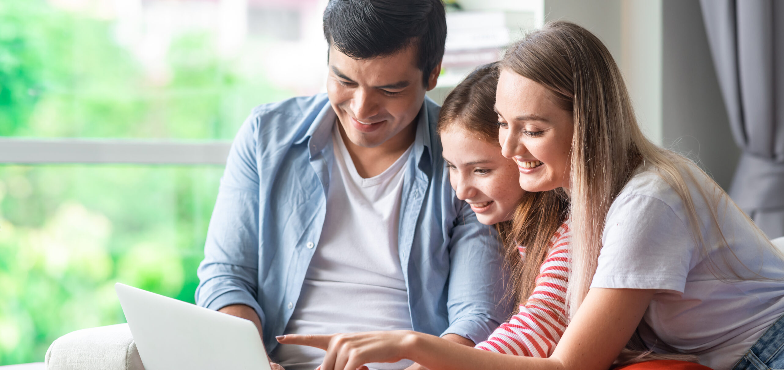 family of three looking at laptop