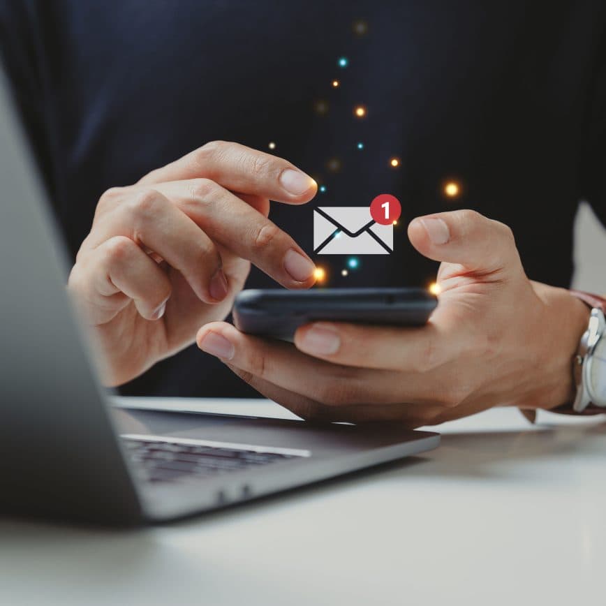 Hands holding a smart phone showing an email icon