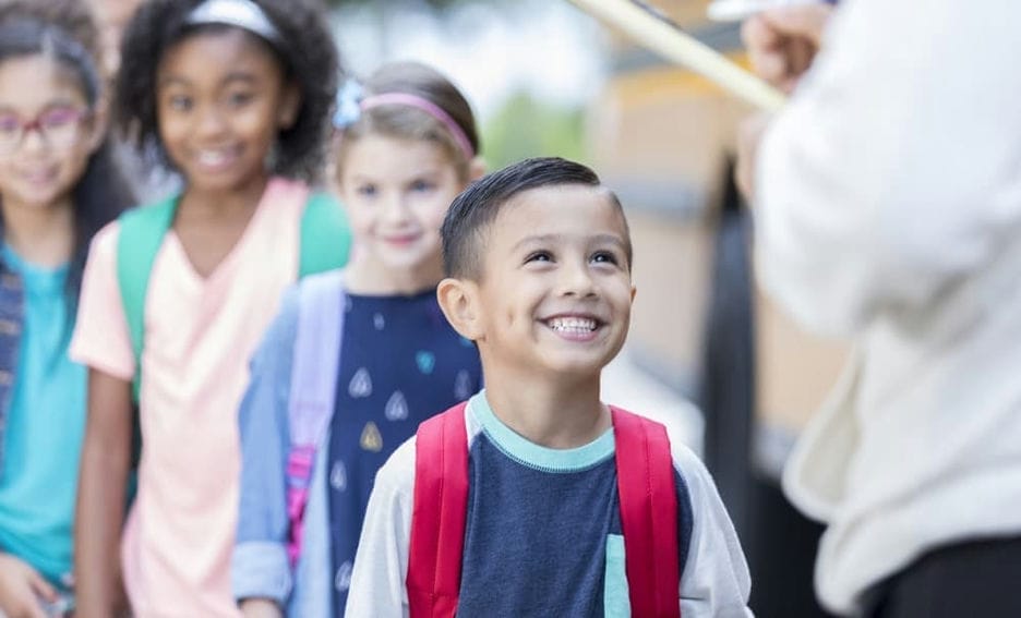 Excited young boy waiting in line after getting off the bus