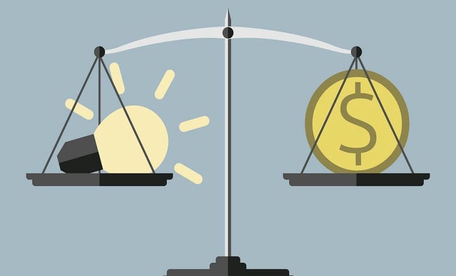 Weighing scale balancing lightbulb with monetary coin