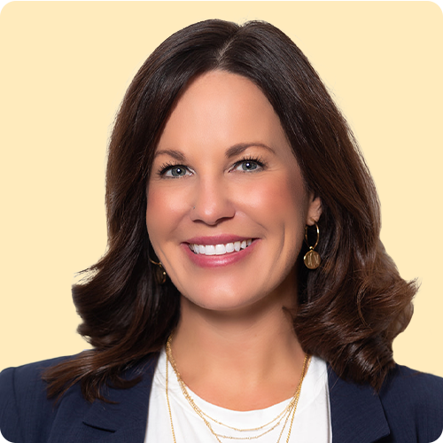 A confident, smiling woman with shoulder length straight dark hair is looking directly at the camera.